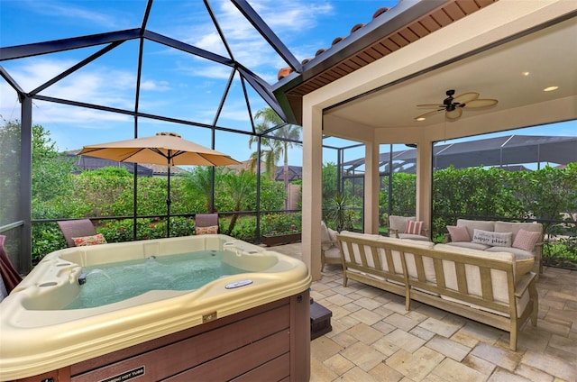 view of patio with a hot tub, glass enclosure, ceiling fan, and an outdoor hangout area