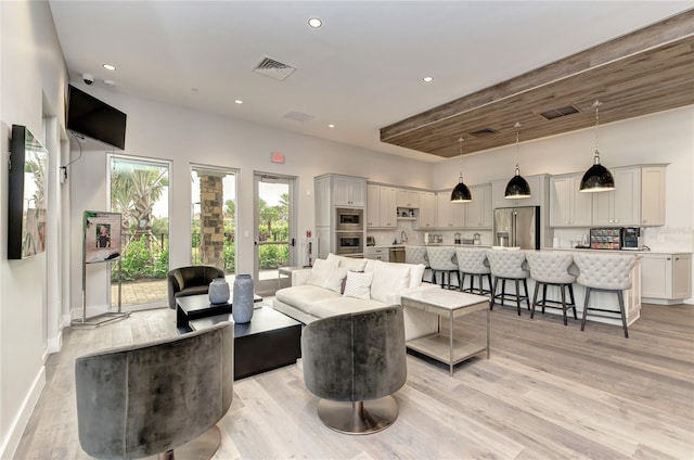 living room with light wood-style flooring, recessed lighting, and baseboards
