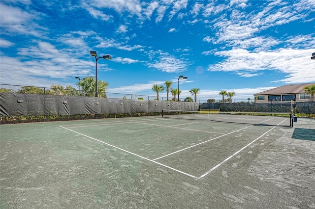 view of tennis court featuring fence