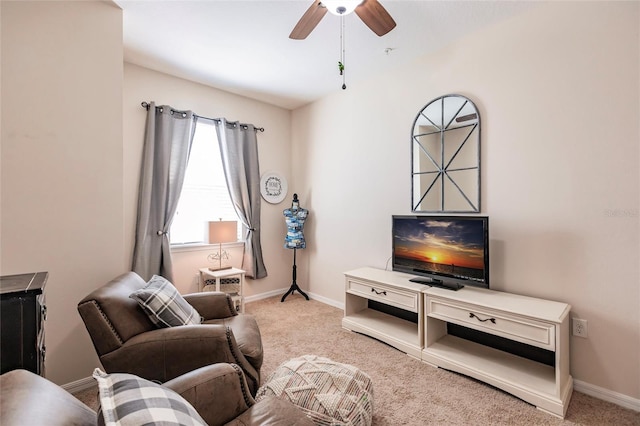 carpeted living area with baseboards and a ceiling fan