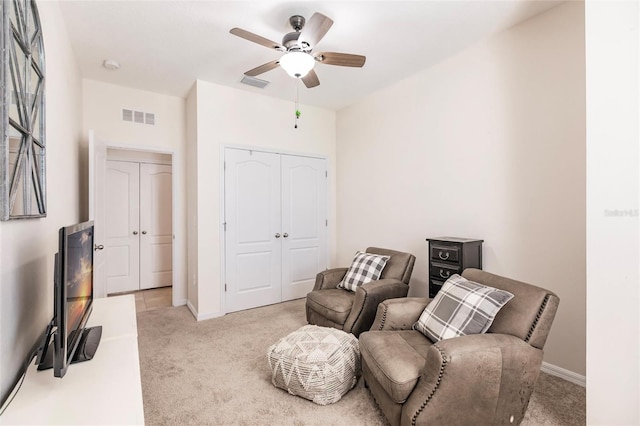 sitting room featuring light carpet, baseboards, and visible vents