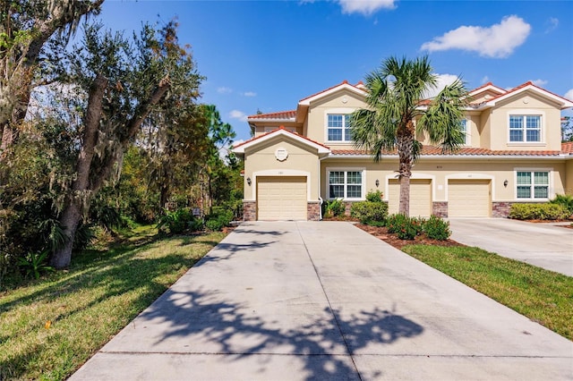 view of front of home with concrete driveway, a tile roof, and stucco siding