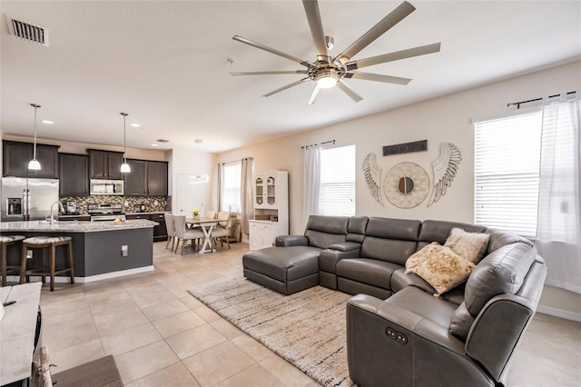 living room with visible vents, a ceiling fan, and light tile patterned flooring