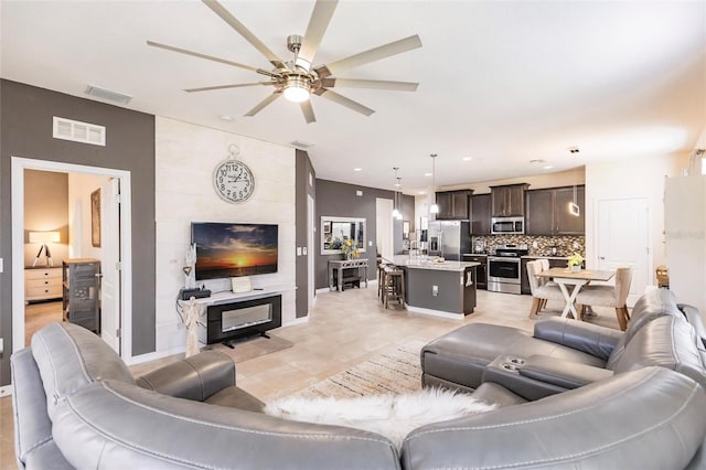 living room with light tile patterned floors, a ceiling fan, visible vents, and recessed lighting