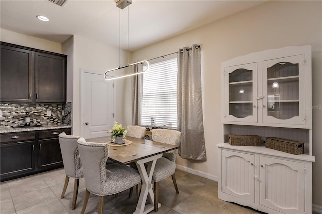 dining space with baseboards and light tile patterned floors