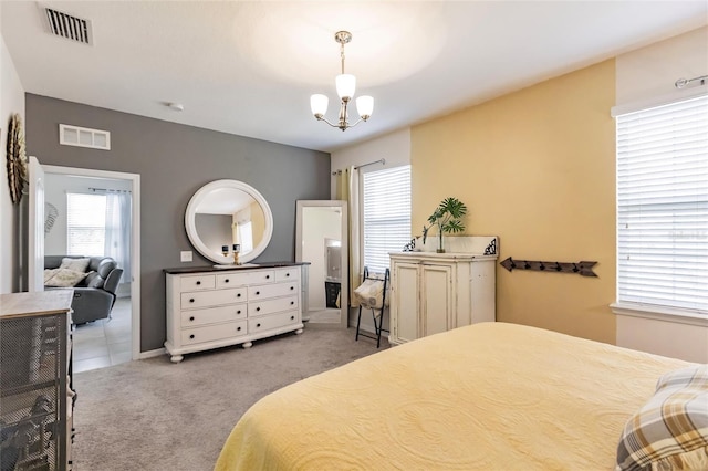 bedroom with baseboards, visible vents, a notable chandelier, and light colored carpet