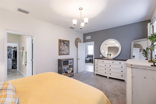 bedroom with visible vents, a notable chandelier, and light colored carpet