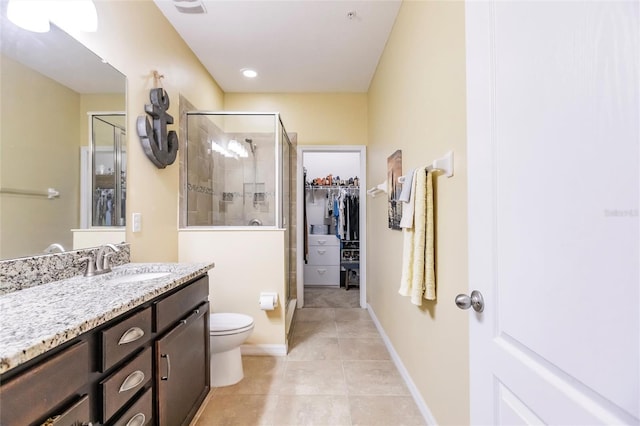 full bath featuring toilet, vanity, a spacious closet, a shower stall, and tile patterned floors