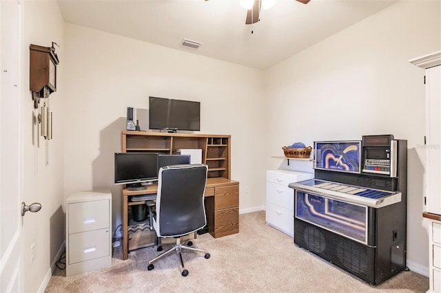 office space with light colored carpet, visible vents, ceiling fan, and baseboards