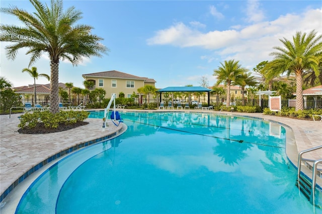 community pool with fence and a patio