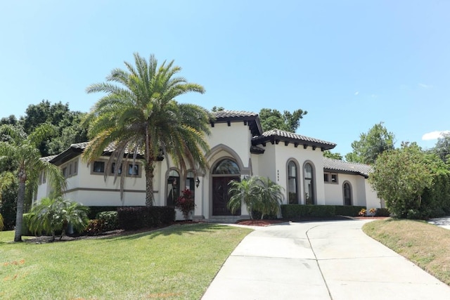 mediterranean / spanish-style home with a front lawn