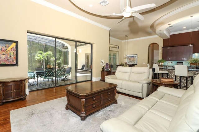 living room featuring ceiling fan, ornamental molding, and light hardwood / wood-style flooring