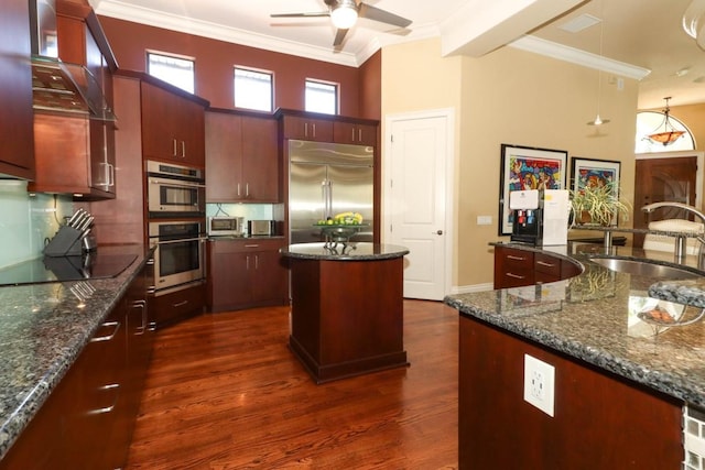 kitchen featuring crown molding, stainless steel appliances, dark hardwood / wood-style flooring, pendant lighting, and sink