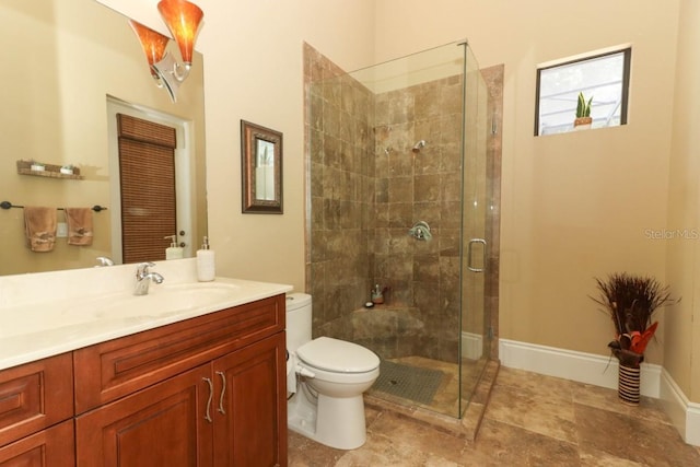 bathroom with a shower with door, vanity, and toilet