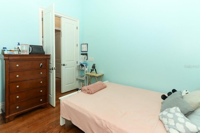 bedroom with dark hardwood / wood-style flooring