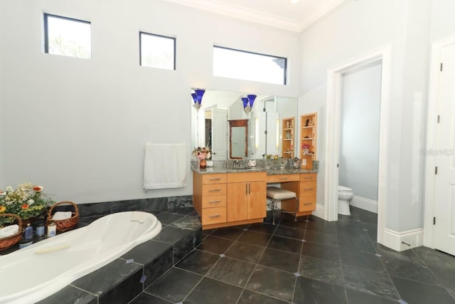 bathroom featuring a wealth of natural light, vanity, toilet, and tiled tub