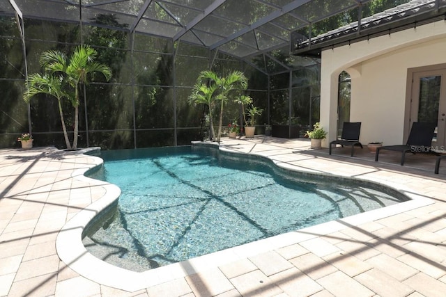 view of pool with glass enclosure and a patio