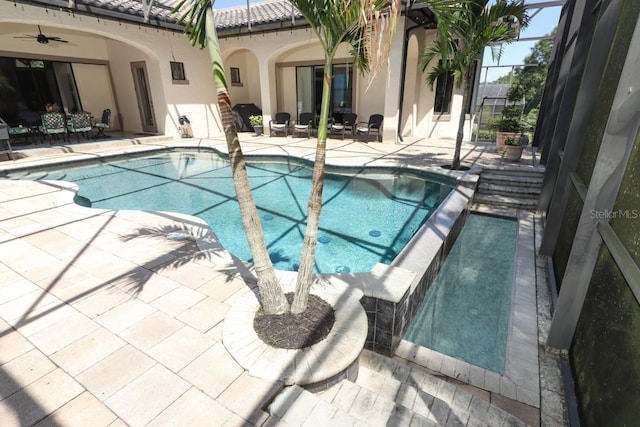 view of swimming pool featuring a lanai, ceiling fan, and a patio