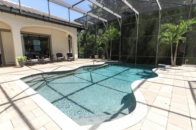 view of swimming pool featuring glass enclosure and a patio area