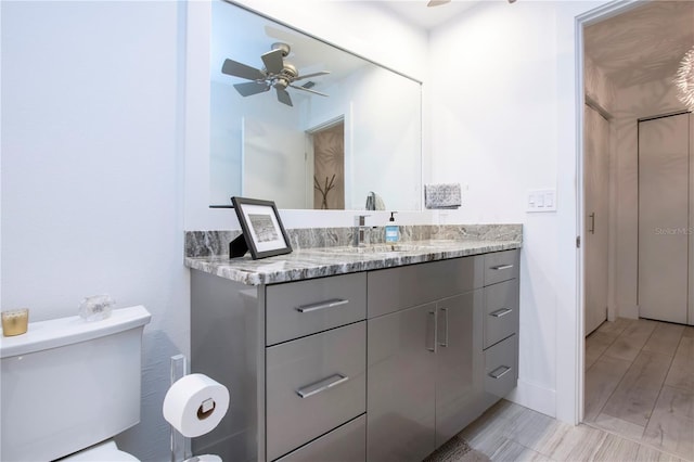 bathroom featuring ceiling fan, vanity, hardwood / wood-style flooring, and toilet