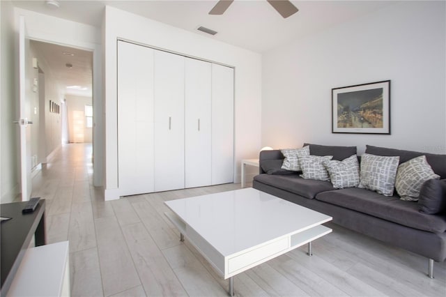 living room with light wood-type flooring and ceiling fan