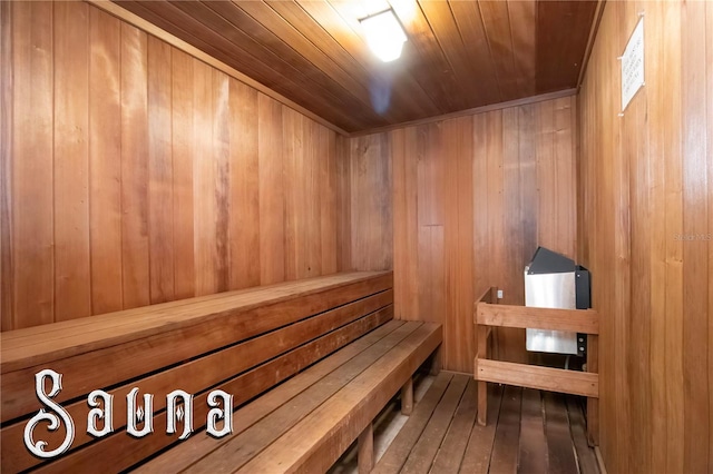 view of sauna featuring wood walls, wooden ceiling, and hardwood / wood-style flooring