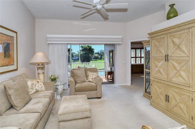 carpeted living room featuring a textured ceiling, ceiling fan, and plenty of natural light