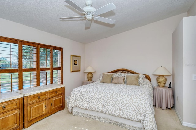 bedroom with a textured ceiling, light carpet, and ceiling fan