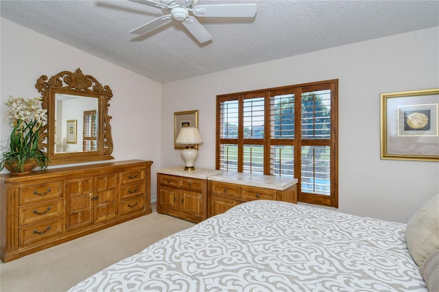 bedroom featuring ceiling fan, a textured ceiling, and light carpet