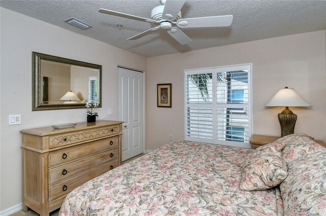 bedroom with a closet, a textured ceiling, and ceiling fan