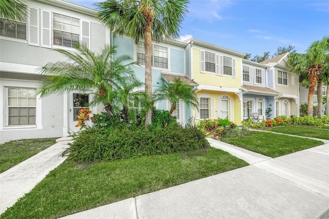 multi unit property featuring a front lawn and a balcony