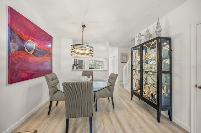 dining space featuring a chandelier and light wood-type flooring