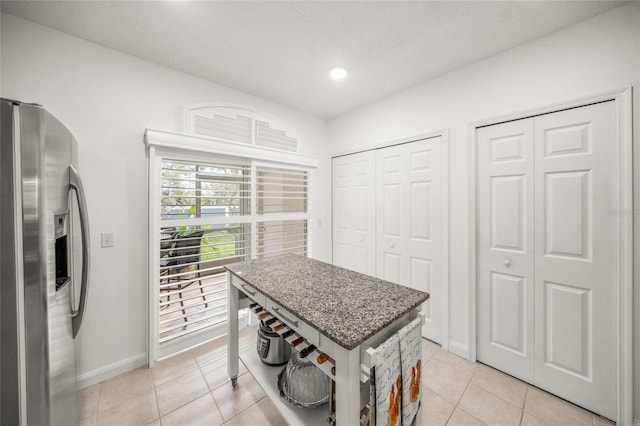 kitchen featuring a textured ceiling, light tile patterned flooring, and stainless steel fridge