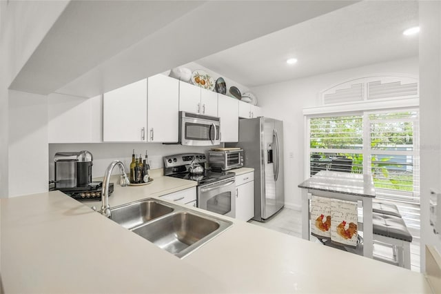 kitchen with white cabinets, appliances with stainless steel finishes, and sink