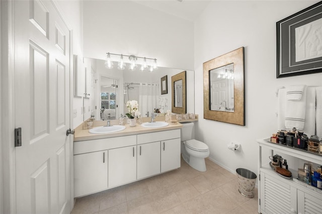 bathroom with toilet, vanity, and tile patterned floors