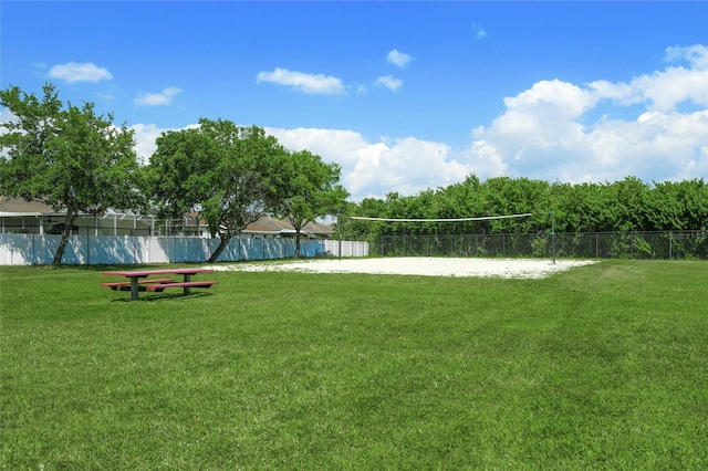 view of community with a lawn and volleyball court