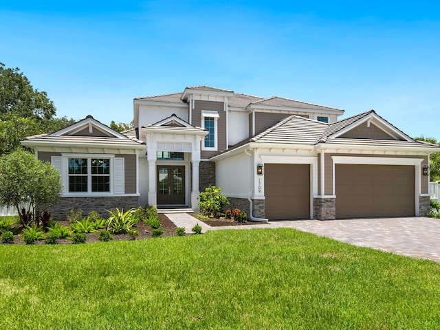 view of front of home featuring a front lawn, a garage, and french doors