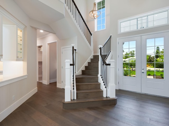 entryway with a chandelier, french doors, dark wood-type flooring, and a high ceiling