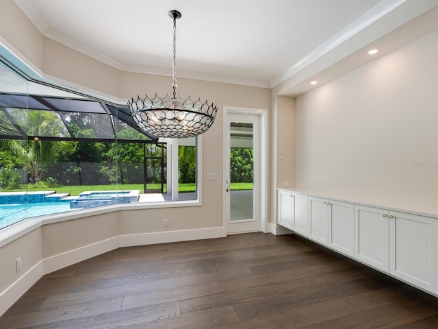 unfurnished dining area with a notable chandelier, dark hardwood / wood-style floors, and crown molding