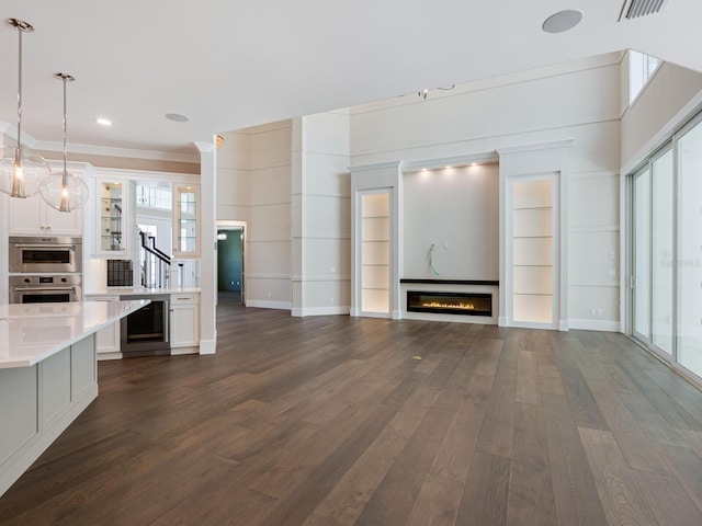 unfurnished living room with crown molding, beverage cooler, and dark wood-type flooring