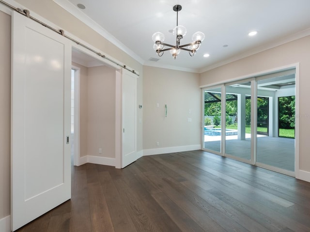 spare room with a barn door, crown molding, dark wood-type flooring, and a notable chandelier