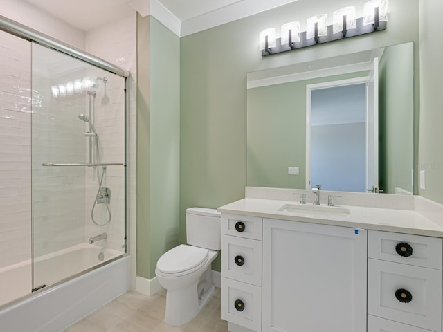 full bathroom with tile patterned floors, bath / shower combo with glass door, toilet, vanity, and ornamental molding