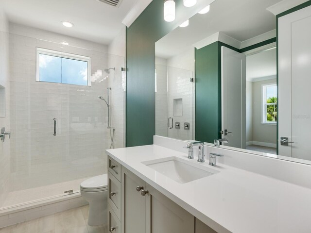 bathroom with walk in shower, vanity, toilet, and plenty of natural light