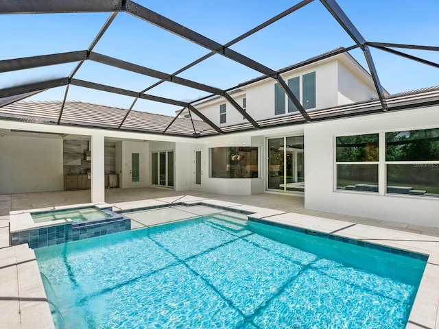 view of swimming pool with glass enclosure, an in ground hot tub, and a patio