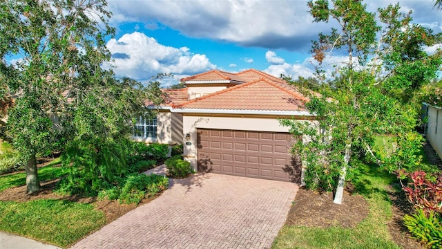 335 River Enclave Ct, Bradenton, FL 34212 - mediterranean / spanish home with a tiled roof, decorative driveway, a garage, and stucco siding