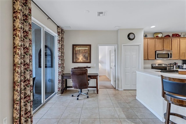 kitchen featuring stainless steel appliances and light tile patterned flooring