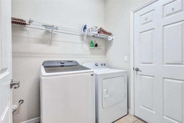 laundry area with light tile patterned floors and washer and dryer