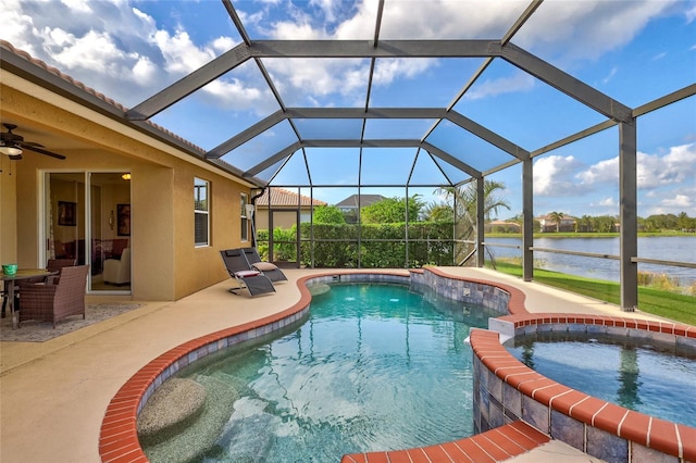 view of swimming pool featuring ceiling fan, a lanai, a patio area, an in ground hot tub, and a water view