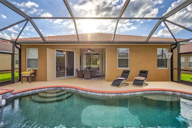 rear view of property featuring ceiling fan, a patio area, and a lanai