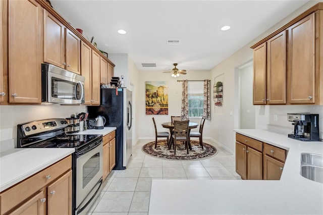 kitchen featuring ceiling fan, light tile patterned floors, and stainless steel appliances